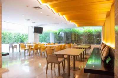 a restaurant with tables and chairs and a large window at Tango Vibrant Living Hotel - SHA Extra Plus in Bangkok