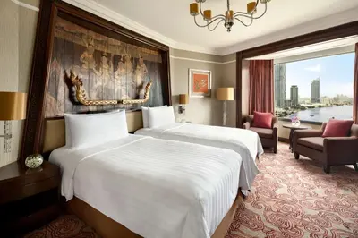 a hotel room with two beds and a large window at Shangri-La Bangkok in Bangkok