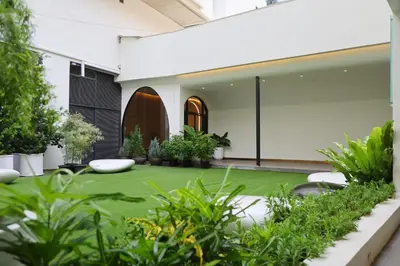 a courtyard with green grass and plants at Graph Hotels Bangkok in Bangkok