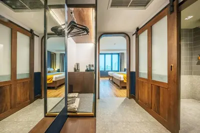 a room with a mirror and a bedroom at Graph Hotels Bangkok in Bangkok