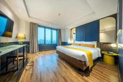 a hotel room with a bed and a desk at Graph Hotels Bangkok in Bangkok