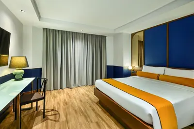 a hotel room with a bed and a desk at Graph Hotels Bangkok in Bangkok