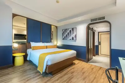 a bedroom with a large bed with blue walls at Graph Hotels Bangkok in Bangkok