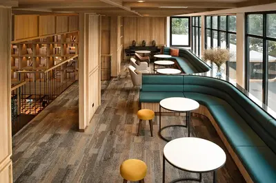a library with tables and chairs and a pool at Graph Hotels Bangkok in Bangkok