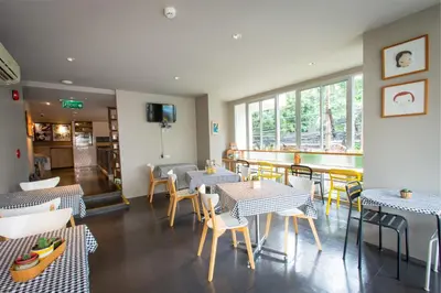 a restaurant with tables and chairs and a balcony at Lemontea Hotel Bangkok in Bangkok