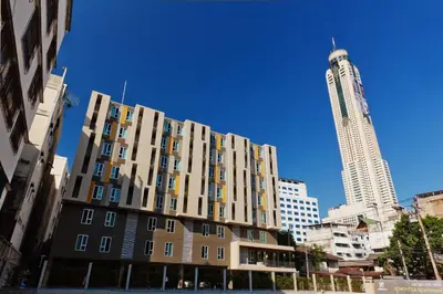 a tall building in a city with a tall skyscraper at Lemontea Hotel Bangkok in Bangkok