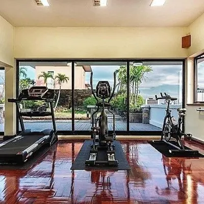 a gym with two exercise bikes and a treadmill at Capital Mansion - SHA Certified in Bangkok