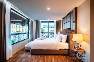 a bedroom with a bed and a large window at The Grand Sala Thai in Bangkok