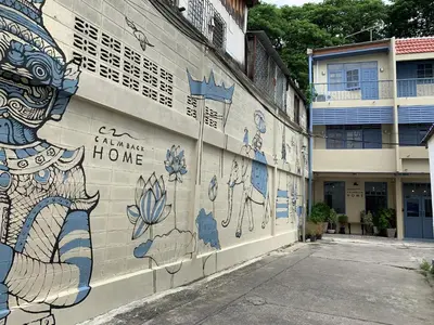 a building with a mural on the side of it at Achcha hotel - itsaraphap MRT station - Wat Arun in Bangkok