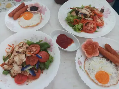 a table topped with plates of food with eggs and vegetables at Baan Anodat in Ban Bang Phai