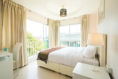 a bedroom with a bed and a large window at Baan Anodat in Ban Bang Phai