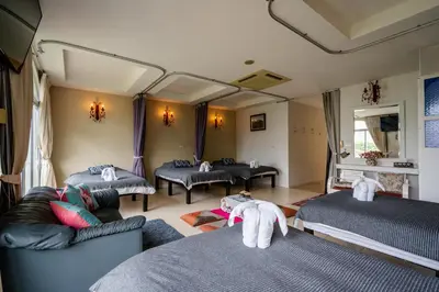 a room with two beds and couches in a room at Baan Anodat in Ban Bang Phai