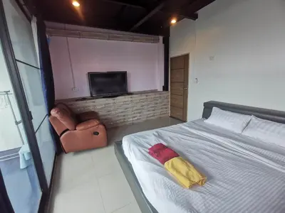 a bedroom with a bed and a chair and a television at Baan1668 Hometel near Chinatown One Bangkok in Bangkok