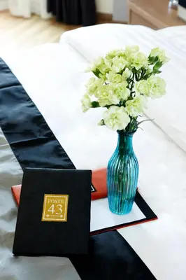 a blue vase with white flowers on a table at Poste 43 Residence in Bangkok