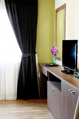 a room with a desk with a television and a window at Poste 43 Residence in Bangkok