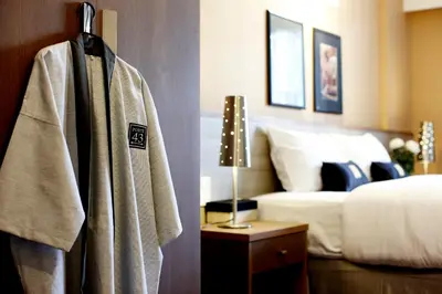 a robe hanging in a hotel room with a bed at Poste 43 Residence in Bangkok