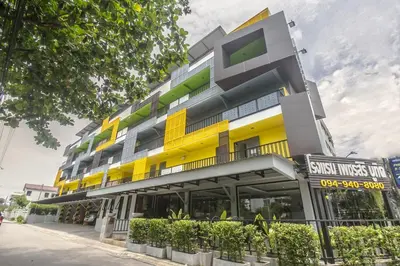 a building with a yellow and green facade at Petchsiri Boutique Hotel เพชรสิริ บูทิค in Bangkok