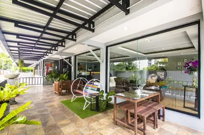 an outdoor patio with tables and chairs and windows at Petchsiri Boutique Hotel เพชรสิริ บูทิค in Bangkok