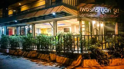a building with a fence and plants in front of it at Petchsiri Boutique Hotel เพชรสิริ บูทิค in Bangkok