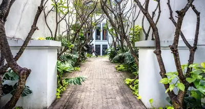 a walkway in front of a house with trees at The Siam in Bangkok