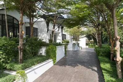 a walkway in front of a house with trees at The Siam in Bangkok