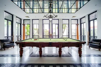 a pool table in a room with windows at The Siam in Bangkok