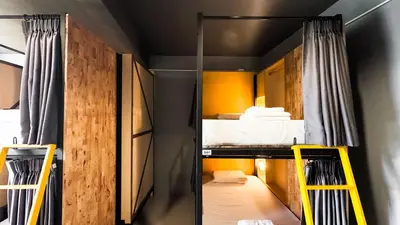 a small room with a bunk bed and yellow ladder at Room 22 Hostel - near Chinatown in Bangkok
