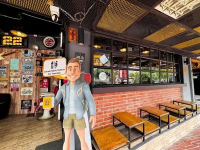 a statue of a man standing in front of a restaurant at Room 22 Hostel - near Chinatown in Bangkok
