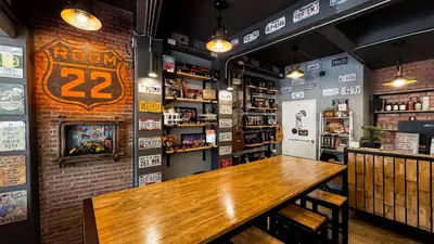 a bar with a wooden table in a room at Room 22 Hostel - near Chinatown in Bangkok