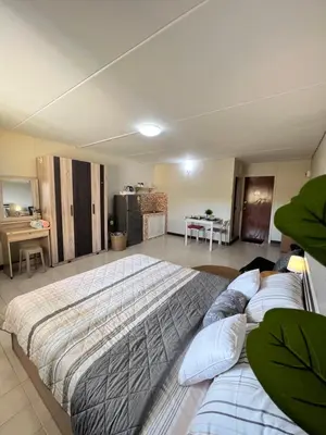 a large bedroom with two beds and a kitchen at Condo Popular T4 Impact Muangthong by Tide in Pak Kret