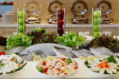 a table with plates of food on a table at The Quarter Hualamphong by UHG in Bangkok