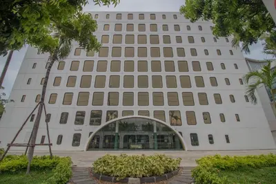 a large white building with an arch in front at Justice Hotel in Bangkok