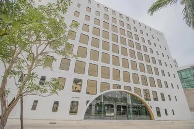 a white building with an arch in front of it at Justice Hotel in Bangkok