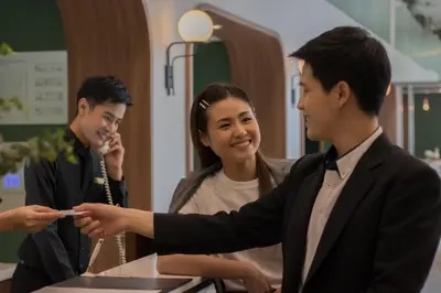 a woman pointing at a man holding a cell phone at Justice Hotel in Bangkok