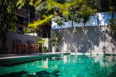a swimming pool next to a building at Cinnamon Hotel Bangkok in Bangkok