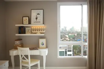 a room with a desk and a large window at Cinnamon Hotel Bangkok in Bangkok