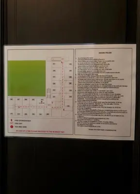 a sign that is hanging on a wall at Baan Wangderm Hotel in Bangkok