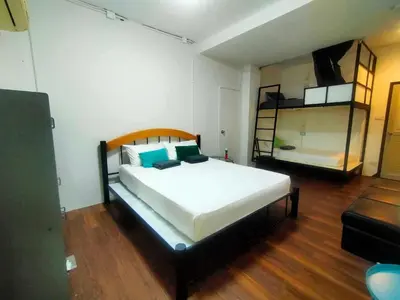 a bedroom with a large bed and two bunk beds at Baan Wangderm Hotel in Bangkok