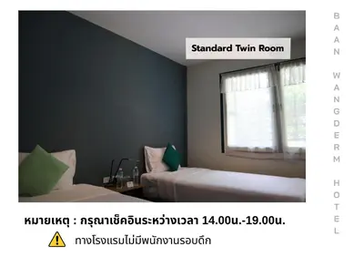 a bedroom with two beds and a window at Baan Wangderm Hotel in Bangkok