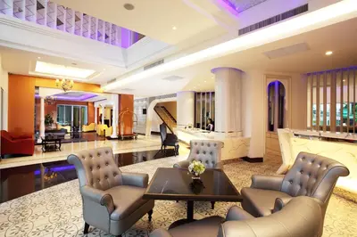 a lobby of a hotel with a table and chairs at Chillax Resort in Bangkok