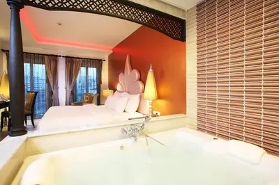 a large bathroom with a tub and a bed at Chillax Resort in Bangkok