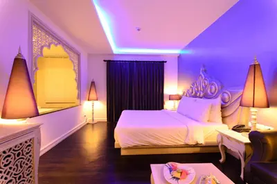 a purple room with a bed and a couch at Chillax Resort in Bangkok