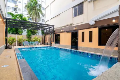 a swimming pool in a building with a fountain at P-Park Hotel Bangkok in Bangkok