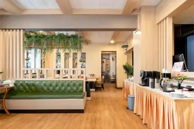 a waiting room with a green couch in a salon at P-Park Hotel Bangkok in Bangkok