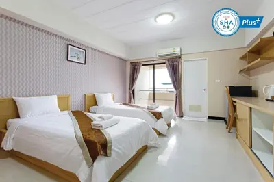 a hotel room with two beds and a desk at P-Park Hotel Bangkok in Bangkok