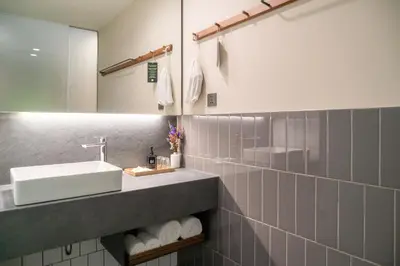 a bathroom with a sink and a mirror at Triple Y Hotel in Bangkok