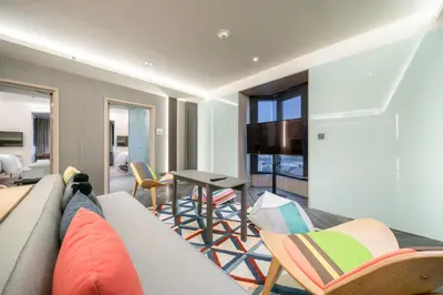 a living room with a couch and chairs and a table at Triple Y Hotel in Bangkok