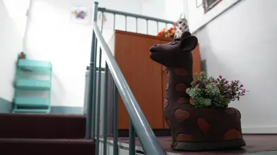 a statue of a dog with a plant on the stairs at INN Room in Bangkok