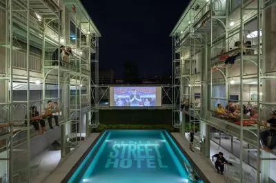 a building with a swimming pool and a tv at Samsen Street Hotel in Bangkok