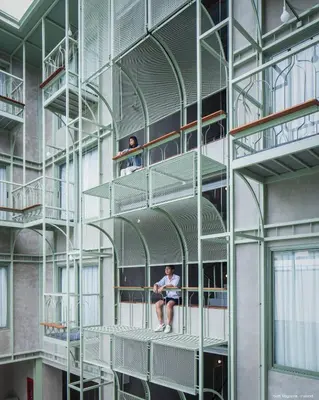 a person sitting on a shelf in a building at Samsen Street Hotel in Bangkok
